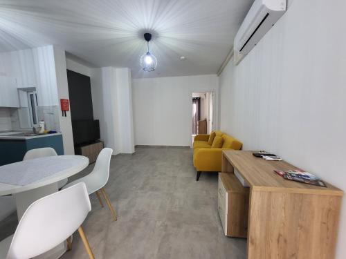 a living room with a table and a yellow couch at St Julian Apartments in St Julian's