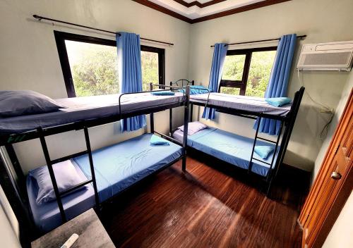 um quarto com 3 beliches e uma janela em Leynes Taal Lake Resort and Hostel em Tanauan