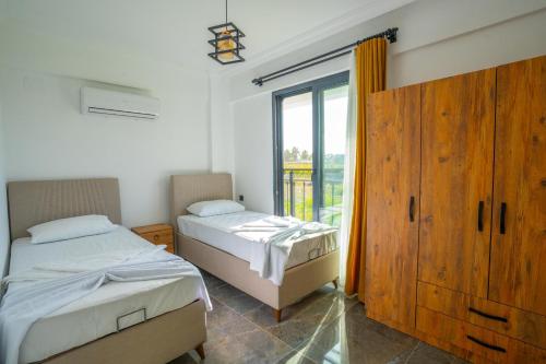 a bedroom with two beds and a large window at Villa Wonder in Dalyan