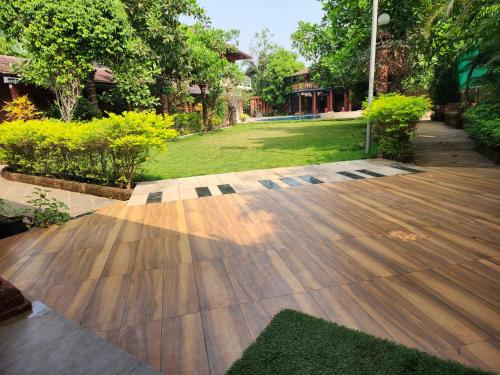 a garden with a wooden floor and a yard at Red Stone Resort in Alibag