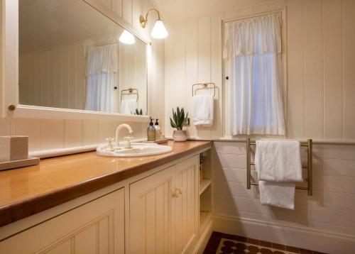 a bathroom with a sink and a mirror at FROGWELL HOLLOW immerse into an idyllic fairytale in Stirling