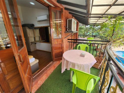 a room with a table and chairs on a balcony at Red Stone Resort in Alibag