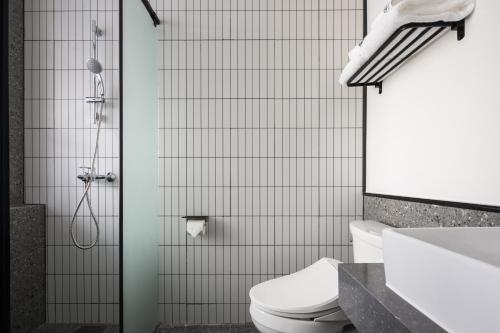 een badkamer met een douche, een toilet en een wastafel bij Hangzhou Desti Youth Park Hostel in Hangzhou