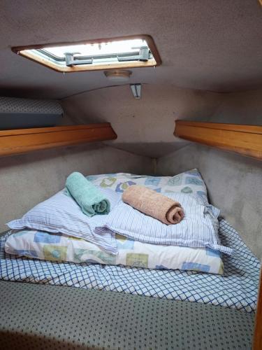 un petit lit dans une chambre avec une fenêtre dans l'établissement Location Unique : Le Bateau d'Antoine à Roscoff, à Roscoff