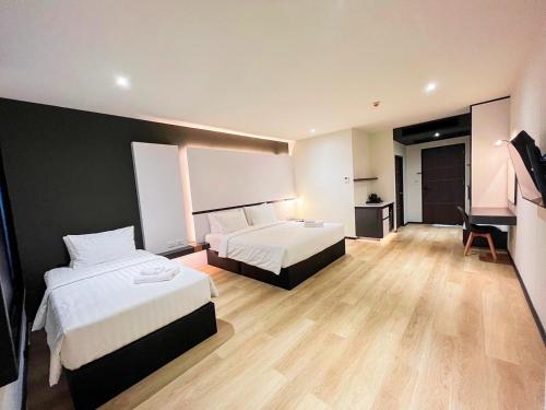 ウドーンターニーにある9D City & 9D Express Hotelのベッド2台とテレビが備わるホテルルームです。