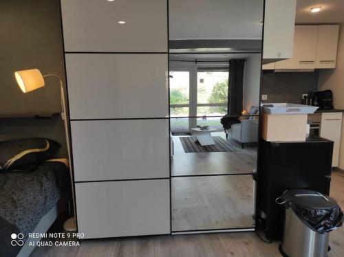 a kitchen and a living room with a glass wall at Studio calme à proximité des 7 meuses in Profondeville