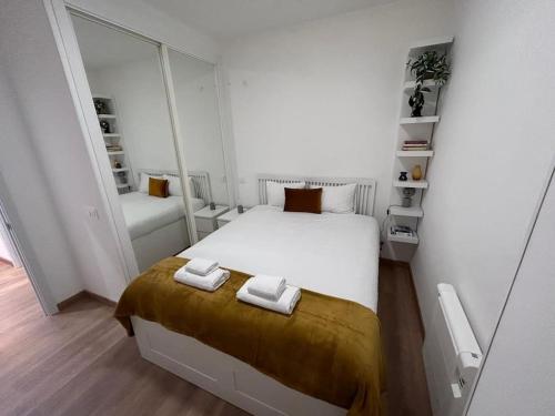 1 dormitorio con 1 cama con 2 toallas en Nice apartment on street level in Vallecas. PNu, en Madrid