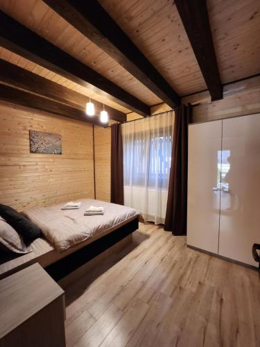 a bedroom with a bed in a wooden room at Apartamente Creasta Craiului in Zărneşti