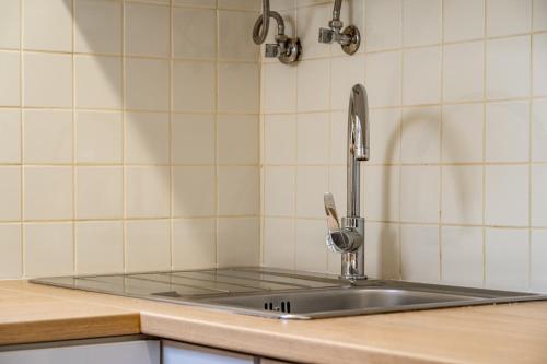 a kitchen sink with a faucet on top of it at Almada Cityscape Apartment in Almada