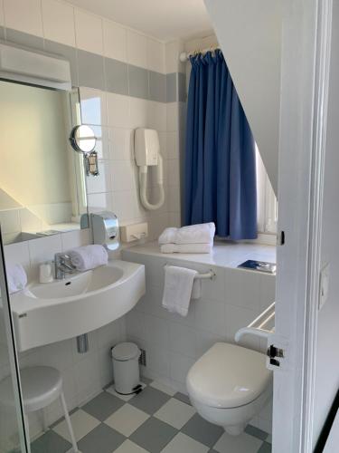 a white bathroom with a sink and a toilet at Logis Hôtel Restaurant le Printania in Dinard