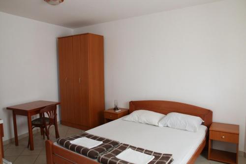 1 dormitorio con 1 cama, armario y mesa en Vera Apartments, en Budva