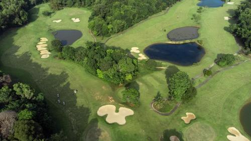 an overhead view of a golf course with three lakes at Turi Beach Resort in Nongsa