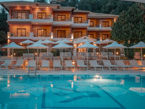 a hotel with a swimming pool with chairs and umbrellas at Dracos Hotel in Parga