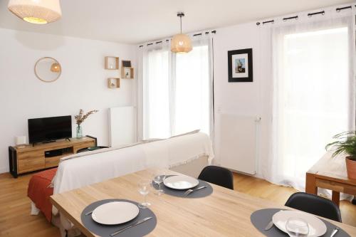 un salon avec une table, des chaises et une télévision dans l'établissement Casa Verde by La Boîte En Plus, à Senlis