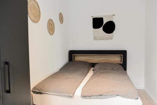 a bed in a white room with two pillows at Homaris Apartments Elmshorn in Elmshorn