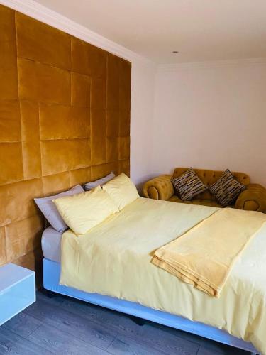 a bedroom with a large bed with a wooden headboard at Minki's place in Roodepoort
