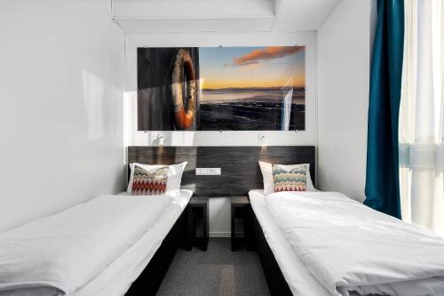 a room with two beds and a picture on the wall at Aiden by Best Western Trondheim Airport in Stjoerdal