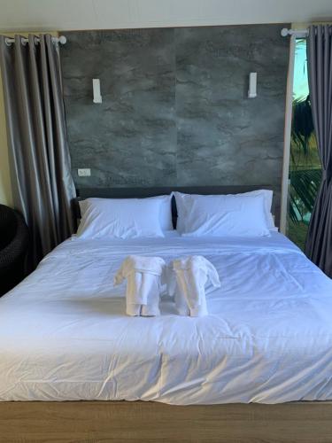 Una cama con dos toallas encima. en Baan Suan Madam บ้านสวนมาดามวังน้ำเขียว, en Wang Nam Khiao