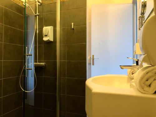 a bathroom with a shower and a sink at Logis Hôtel Restaurant le Printania in Dinard