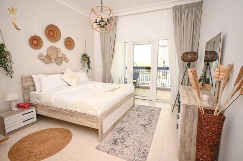 a white bedroom with a bed and a balcony at Yas Natura Bliss 1BR Apartment in Abu Dhabi