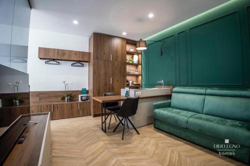 un soggiorno con divano verde e tavolo di Salotto Room Boutique a Pescara