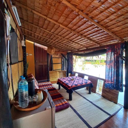una sala de estar con una mesa y un sofá en Bar Horizon Hostel, en Chumphon