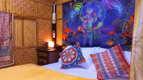 Schlafzimmer mit einem Bett mit Wandgemälde in der Unterkunft Bar Horizon Hostel in Chumphon