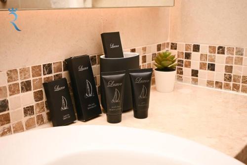 a group of three black shampoo bottles on a bathroom counter at Yas Natura Bliss 1BR Apartment in Abu Dhabi