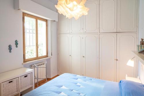een slaapkamer met een blauw bed en een kroonluchter bij N269 - Numana, villa singola quadrilocale con giardino in Numana