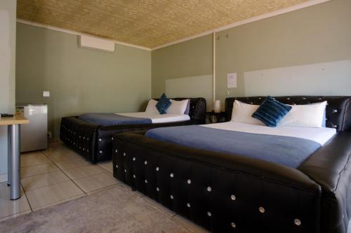 a room with two beds and a couch at Alimop Bed and Breakfast in Midrand