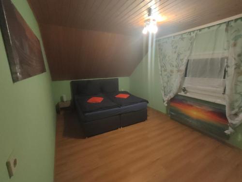 ein kleines Wohnzimmer mit einem Sofa und einem Fenster in der Unterkunft Ferienwohnung Burmester in Wittenborn