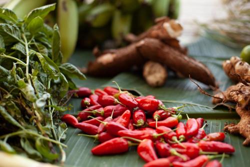 a pile of red peppers on a table with other vegetables at The Resort at Isla Palenque Member of the Cayuga Collection in Boca Chica