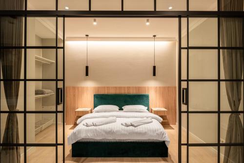a bedroom with a large bed and glass walls at Urban Studio @ Record Park in Cluj-Napoca