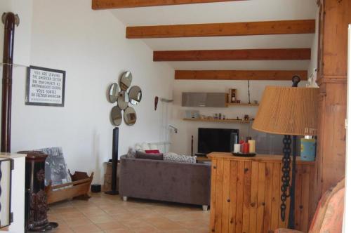 ein Wohnzimmer mit einem Sofa und einem TV in der Unterkunft La Villa du bonheur in Puy-Saint-Martin