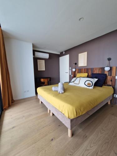 a bedroom with a large bed with yellow sheets at Chez Charly in Bordeaux