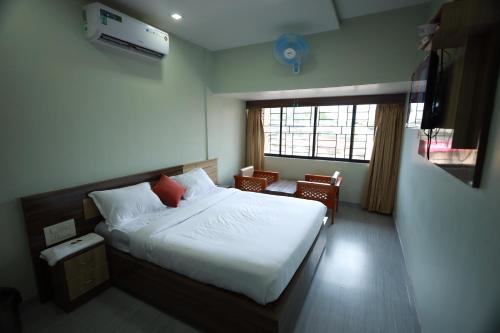 ein Schlafzimmer mit einem großen Bett und einem Fenster in der Unterkunft Haksons Residency in Mananthavady