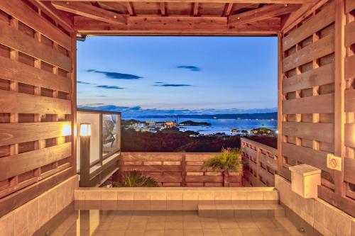 um quarto com vista para o oceano a partir de uma varanda em 南紀白浜ビューポイント em Shirahama