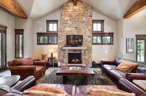 - un salon avec des canapés et une cheminée en pierre dans l'établissement The Shores Riverside Townhome: Peaceful Luxury, à Gold Hill