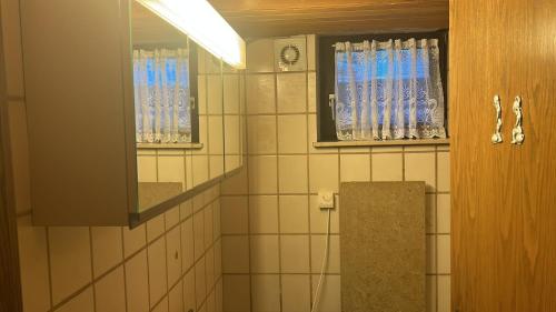a bathroom with a window and a tiled wall at Souterrainwohnung Zum Leiselsee in Baunatal