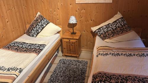 2 camas en una habitación con una lámpara en una mesa en Souterrainwohnung Zum Leiselsee en Baunatal