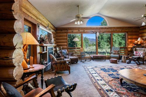 Elle comprend un salon doté de meubles et d'une grande fenêtre. dans l'établissement Swan River Lodge Home: Spacious, Hot Tub, à Gold Hill