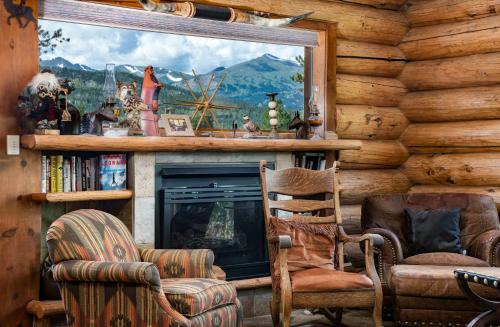 un salon avec cheminée dans une cabane en rondins dans l'établissement Swan River Lodge Home: Spacious, Hot Tub, à Gold Hill