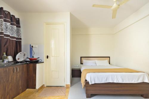 een witte slaapkamer met een bed en een kast bij Stayhome Classic in Bangalore