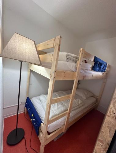Ce lit se trouve dans un dortoir doté de 2 lits superposés et d'une lampe. dans l'établissement Appartement de 32m² au cœur de la Joue du Loup, à Saint-Étienne-en-Dévoluy