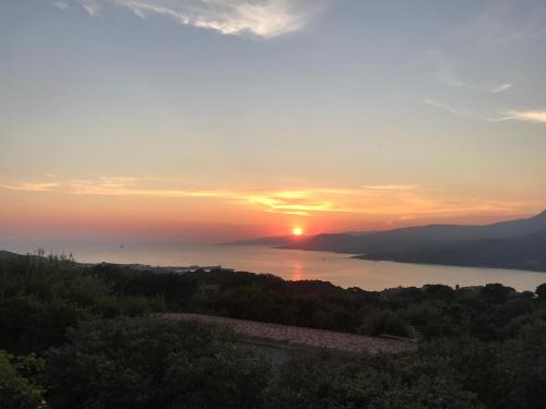a sunset over a body of water with the sun setting at Résidence île de beauté in Propriano