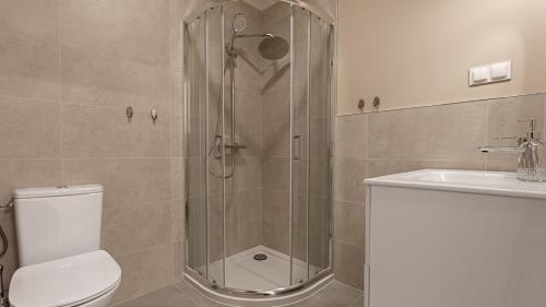 a bathroom with a shower and a toilet and a sink at VacationClub - Apartamenty Zakopiańskie Apartament 141 in Zakopane