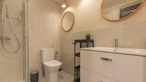 a bathroom with a toilet and a sink and a mirror at VacationClub - Apartamenty Zakopiańskie Apartament 427 in Zakopane