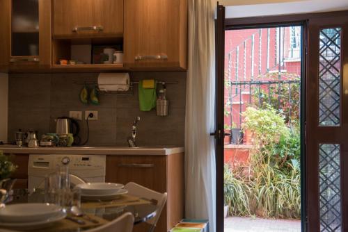 una cocina con mesa y una puerta a un jardín en Aventino apartment en Roma