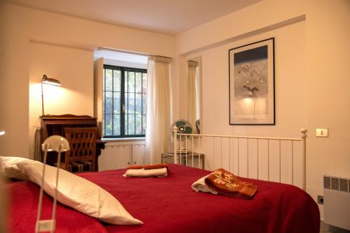1 dormitorio con cama roja y manta roja en Aventino apartment en Roma