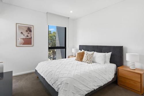 a bedroom with a large bed and a window at Addison's Escape - A Breezy Beachfront Beauty in Shellharbour